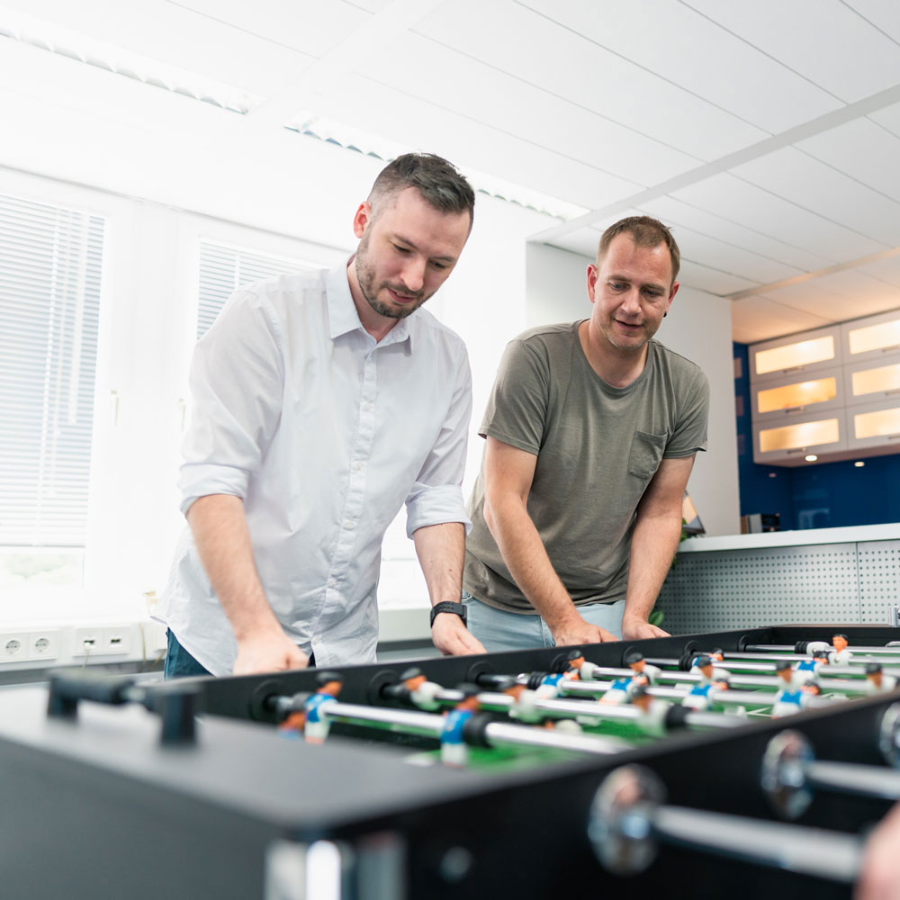 Lorent IT Mitarbeiter spielen am Kicker