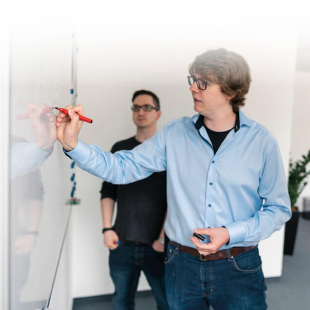 Lorent IT Mitarbeiter zeichnet mit Stift an Whiteboard